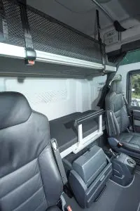 De koelkast en console met schakelbediening en handrem nemen veel ruimte in op de vloer.
