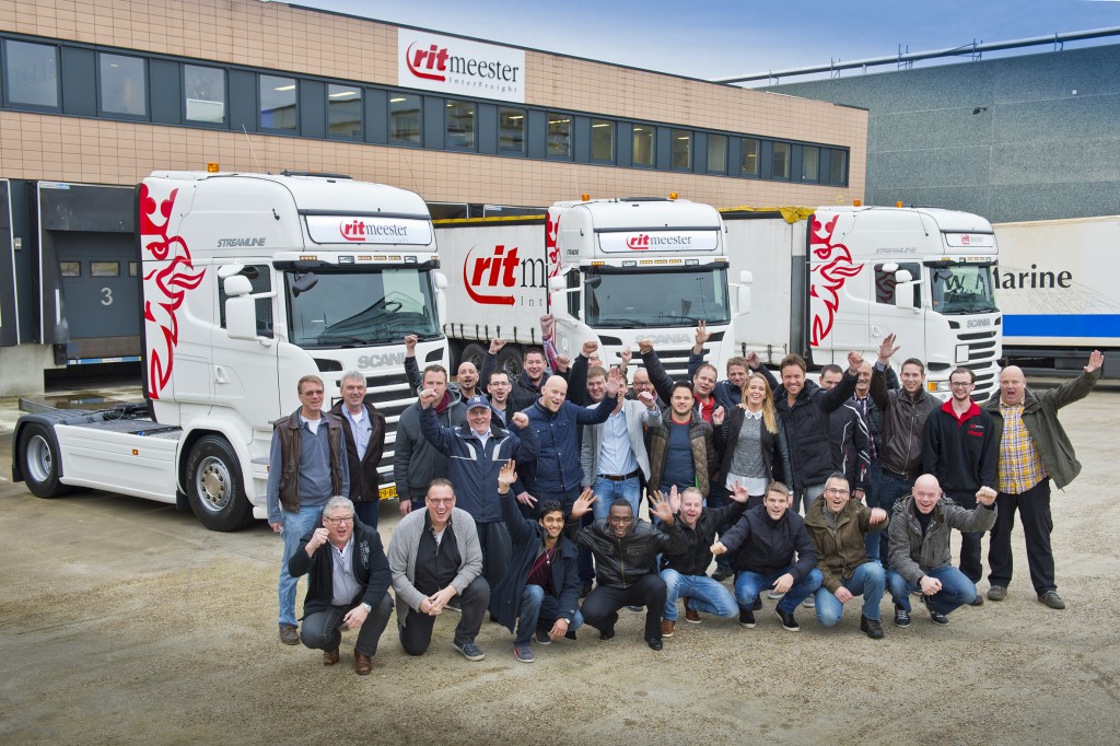 De chauffeurs van Ritmeester – bijeen voor de feestelijke opening van het nieuwe pand – verwelkomen de nieuwe Scania’s met het nodige enthousiasme. 